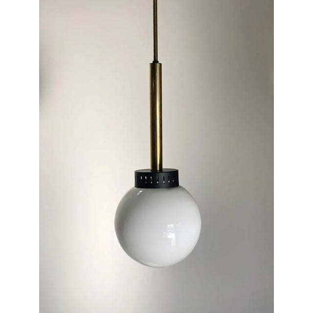 1950s chandelier of Stilnovo, opal glass diffuser, brass structure and black lacquered metal This piece is designed in the...