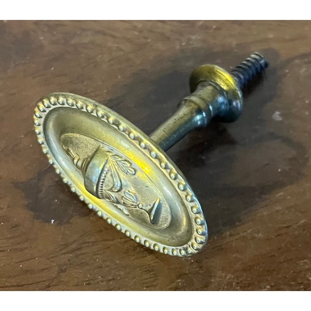 Antique early 19th c. American Federal neoclassical brass oval mirror support or picture hook. Decorated with a classical...