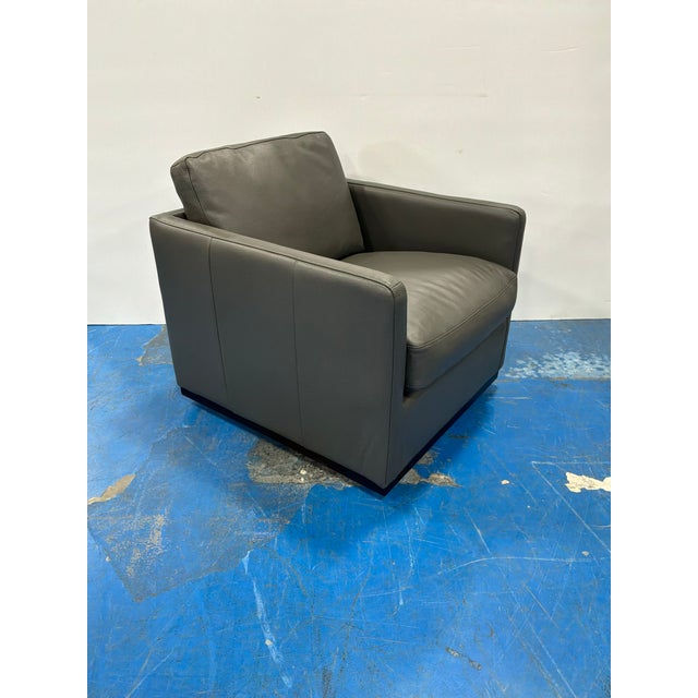Stylish modern Leather Swivel Chair Dark Grey leather track arm. Showroom floor sample.