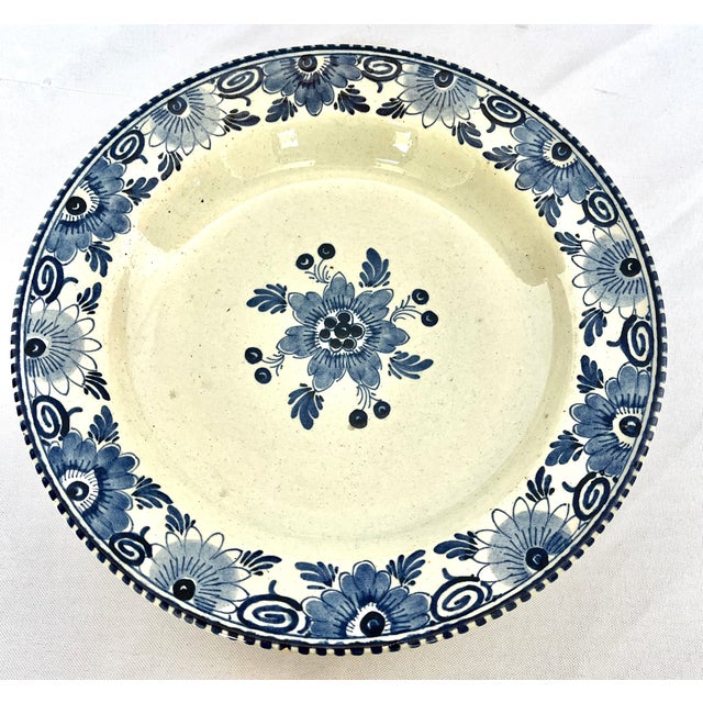 Antique hand painted classic blue and white delft bowls. Floral border and single center blossom. Each bowl signed on the...