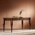 Solid mahogany desk in lineage finish, featuring hand carved sculptural figure ornaments in gold leaf and one sliding...