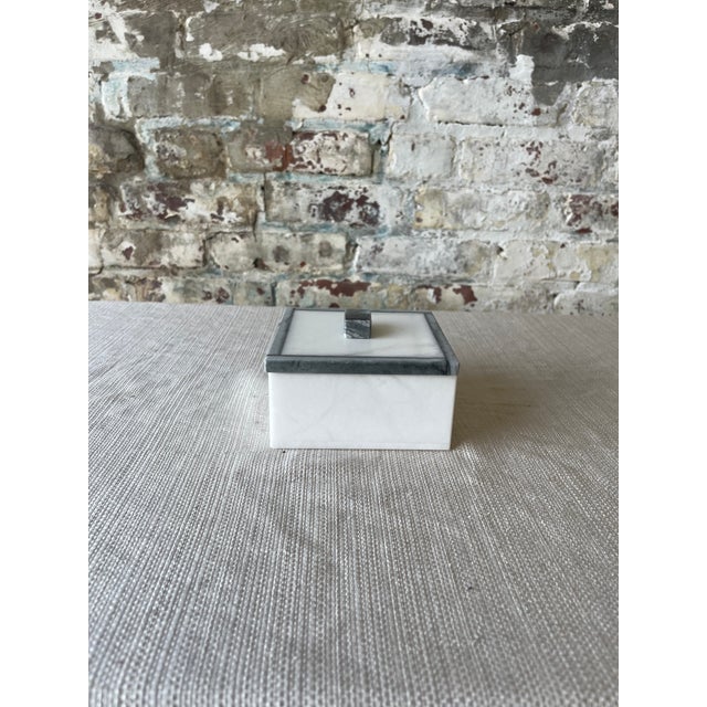 "A study in quiet luxury. This square marble box features a white base with elegant gray veining and a matching lid...