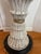 carved wooden fluted hourglass table. dark circular base with gold accents.