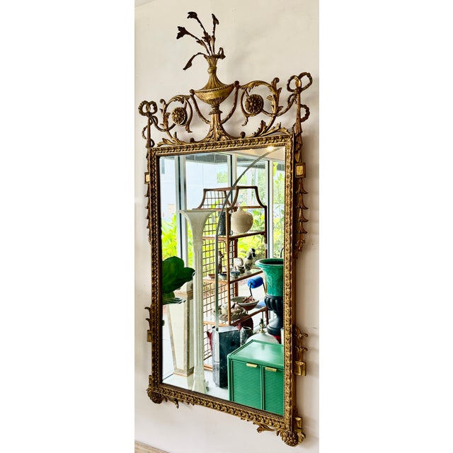 Antique carved wood wall mirror. Robert Adam style British Georgian giltwood overmantel pier mirror. It features a...