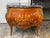Design Plus Gallery presents a Louis XV Style French Bombe Commode. It has a black marble top, floral marquetry, and...