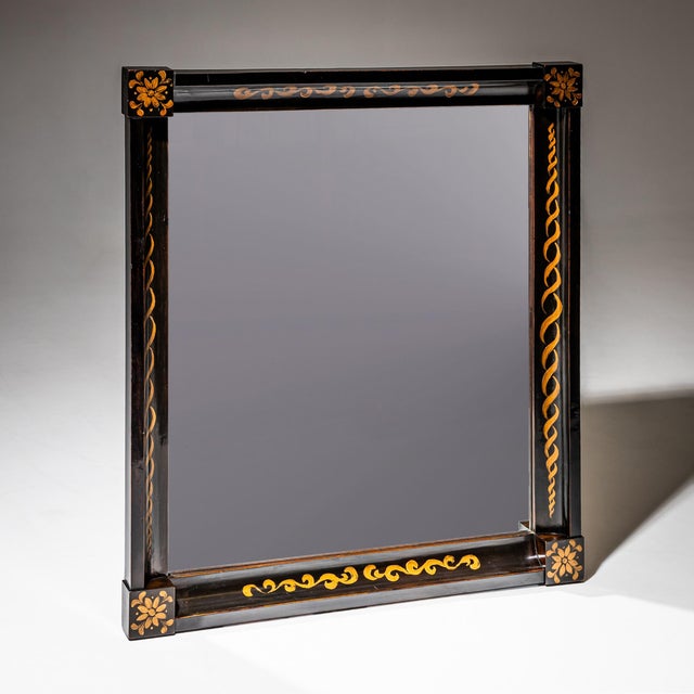 Charming rectangular Biedermeier mirror with an ebonized wooden frame featuring a pronounced concave molding and square...