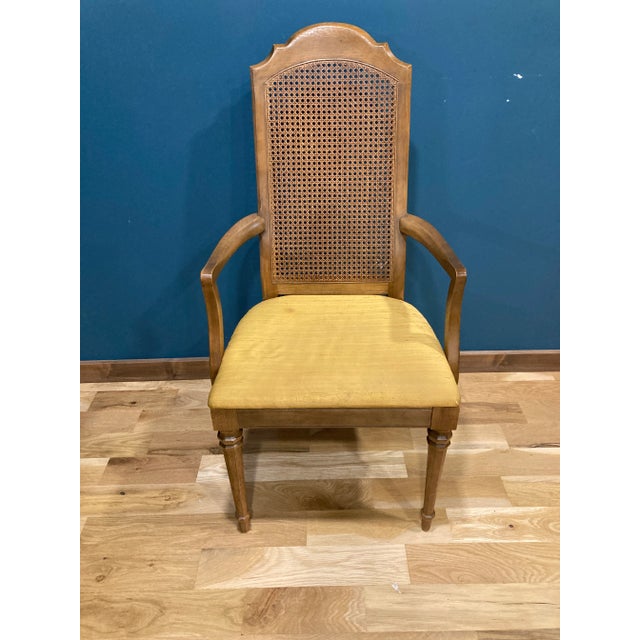 A refined vintage Drexel armchair featuring a classic cane back, sculpted solid wood frame, and upholstered seat. Known...