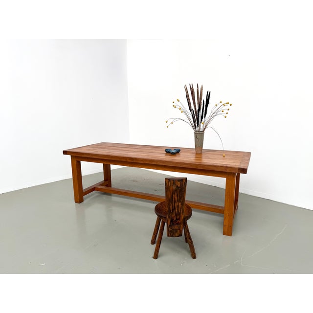 A solid beechwood farmhouse table with a striking physical presence. The substantial thickness of the tabletop conveys a...