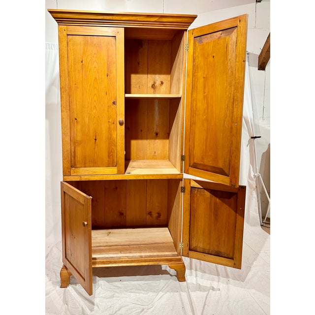 Handmade late 20th-century solid knotty pine cabinet featuring four paneled doors, farmhouse styling, and abundant...