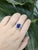 This elegant tanzanite ring showcases a 4.39-carat oval-shaped center stone (10x8mm) with striking deep blue-violet hues....