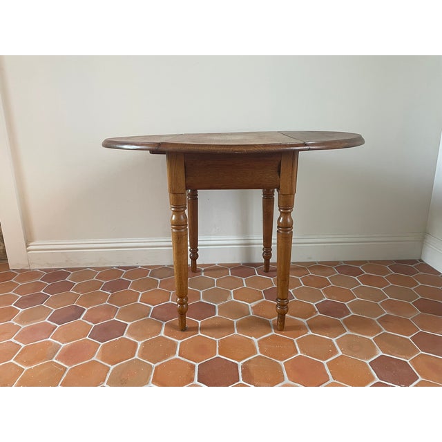 Add classic Early American charm to your interior with this vintage mid-century drop-leaf side table. Heavily inspired by...