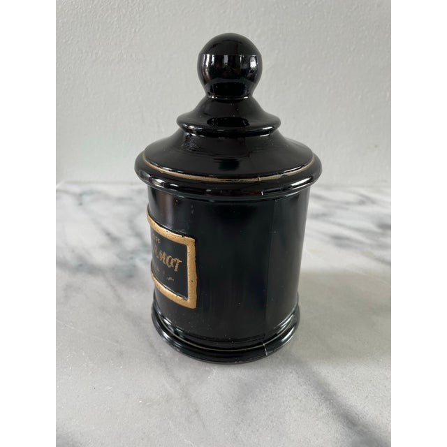 A vintage black glass apothecary jar from Jean Vivaudou Co. Inc, originally holding Orloff Bergamot Men's Bath Talc. The...