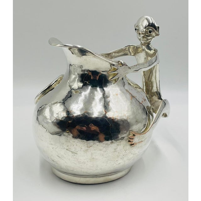 A whimsical and sculptural silver-plated water pitcher designed and handcrafted in Taxco, Mexico by celebrated artist...