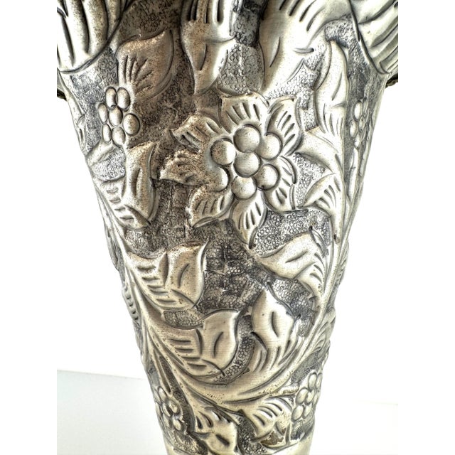 A finely detailed vintage European silverplate vase featuring repoussé floral and foliate motifs in high relief, set on a...