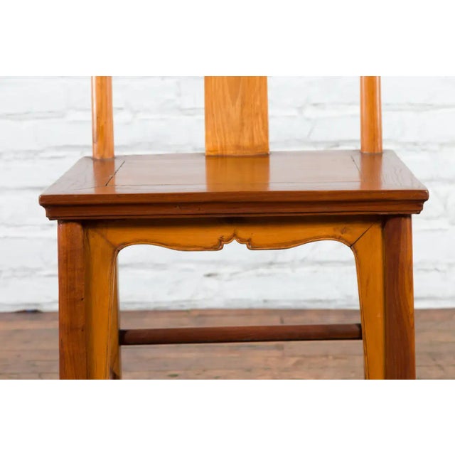 A Chinese Qing Dynasty period lamp hanger chair from the early 20th century, with hand-carved medallion on the back splat,...