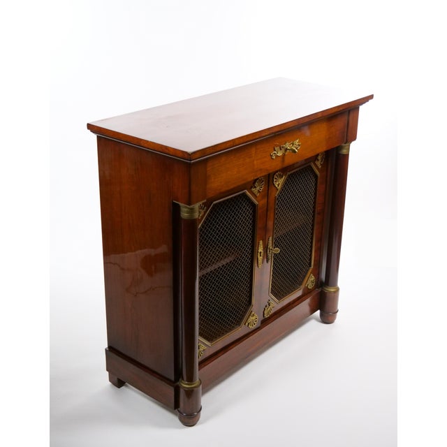 An elegant English rosewood server cabinet dating to circa 1880, reflecting the refined neoclassical influences and...
