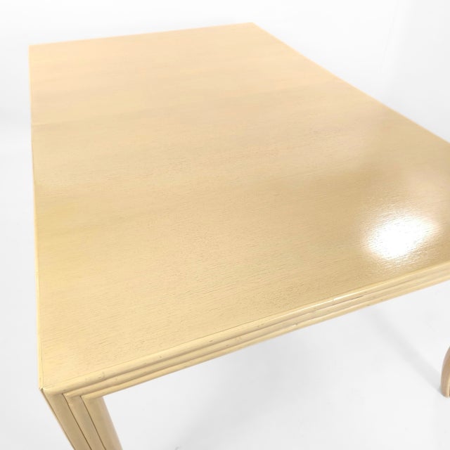 Rare find, McGuire oak dining table with a custom creamy-white finish. The table is framed by a faux-bamboo reeded apron...