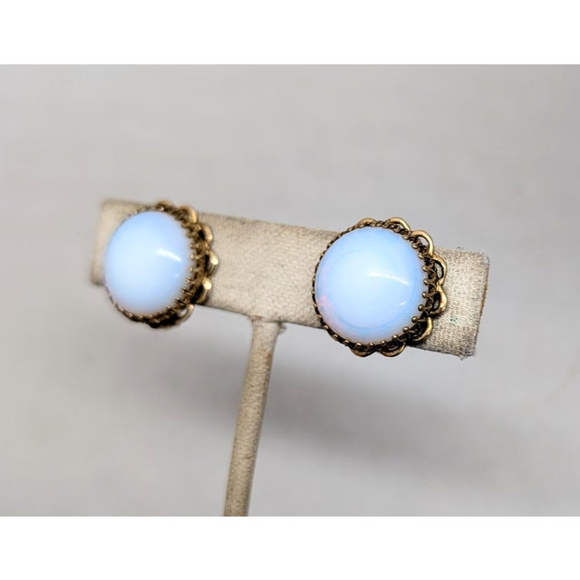 1950s round goldtone prong set single cabochon faux-moonstone with goldtone loops around the edges butterfly clip back...