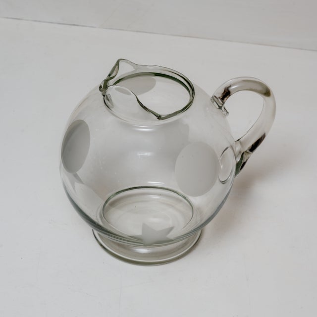 Delightful, round transparent glass pitcher featuring frosted star and circle motifs.
