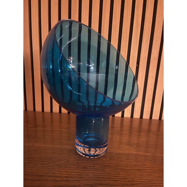 This striking hand-blown studio glass vessel is crafted in rich ocean-blue glass with an expressive asymmetrical...