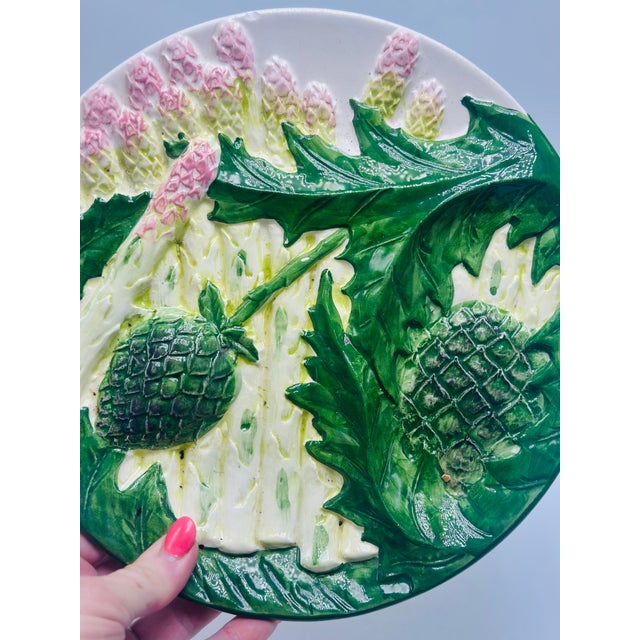 This is a decorative majolica-style ceramic plate, richly modeled and glazed in high relief. Front / design: • The surface...