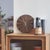 This simple wooden wall clock features a round dial with natural, fan-shaped wood grain and a warm wood tone. The hands...