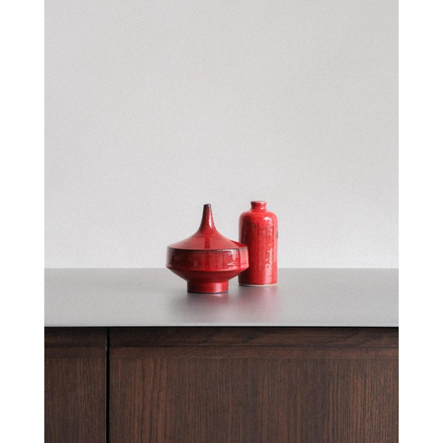 A pair of belgian mid-century ceramic vases attributed to rogier vandeweghe for amphora. Both are finished in the intense...