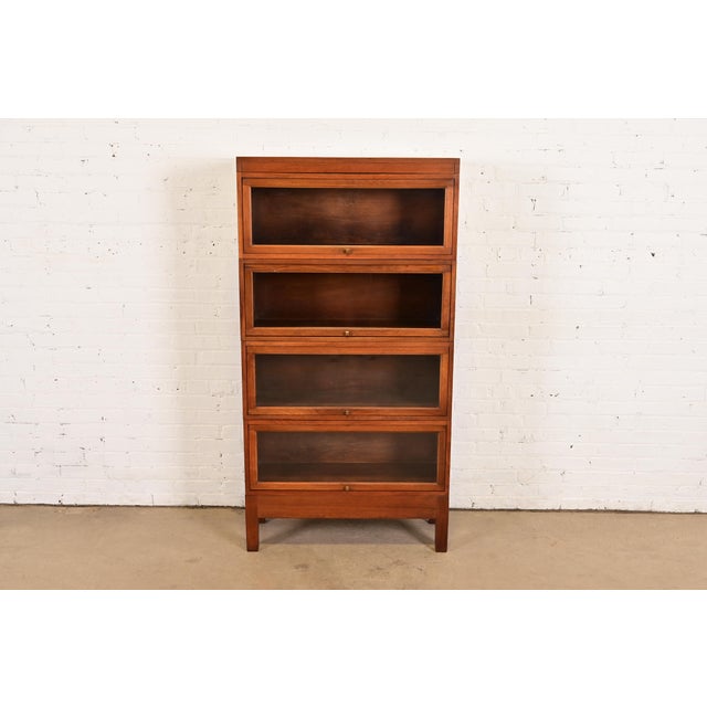 A gorgeous antique Arts & Crafts four-stack barrister bookcase By Stow Davis USA, Circa 1920s Mahogany, with glass front...