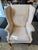 This is a vintage wingback chair. It has a mahogany Chippendale style base. It has a cream colored fabric with a geometric...
