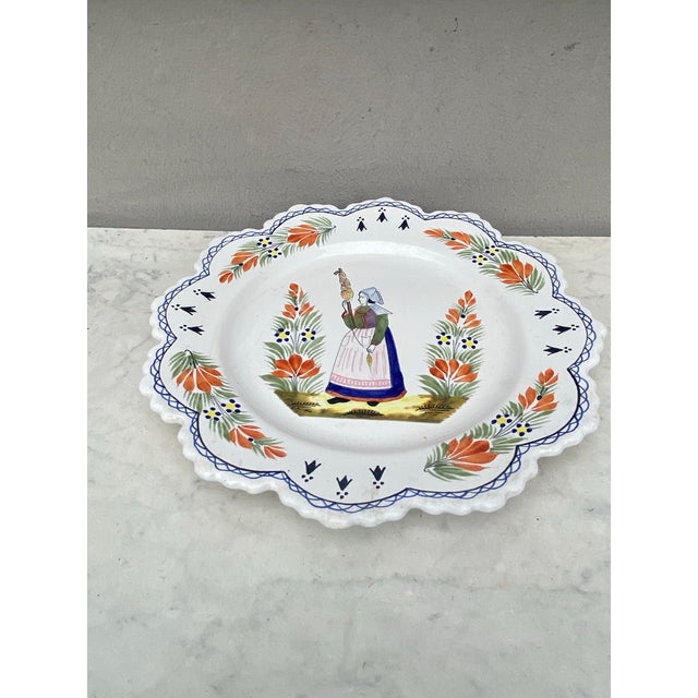 French Faience Plate Henriot Quimper Circa 1950. woman from Brittany with a spinning wheel. 10.5 inches diameter.