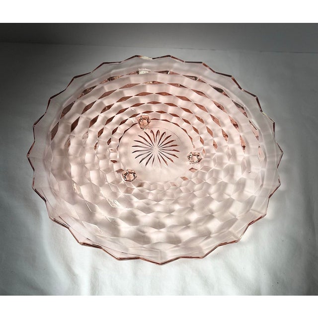 A beautiful delicate pale pink footed glass cake platter, vintage Whitehall, Indiana glass. A great piece to add to any...