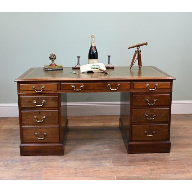 Handsome English Victorian pedestal desk crafted from mahogany Rectangular top inset with a green tooled leather writing...