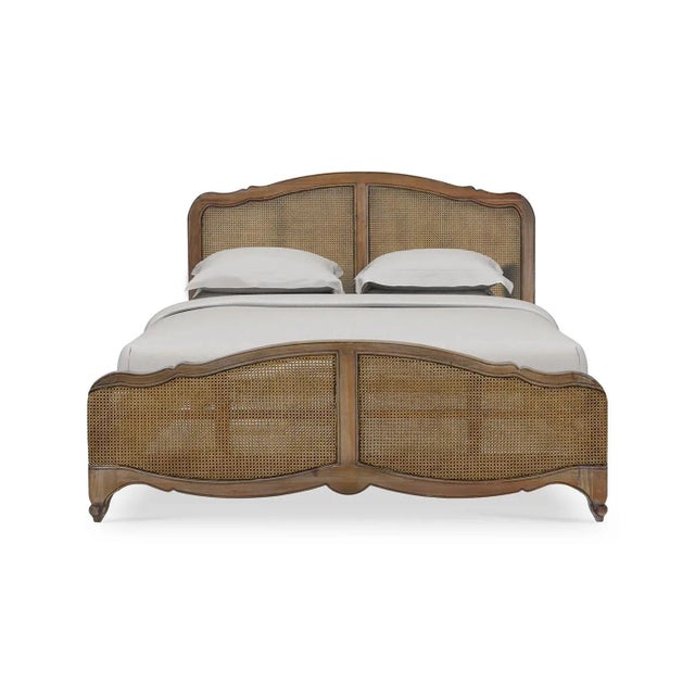 An 18th-century inspired, Louis XV-style carved bedframe, in a medium hand-rubbed and distressed Straw Wash finish. The...