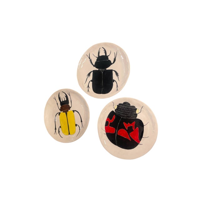 This unique set of three vintage decorative ceramic plates features bold, hand-painted insect motifs, making it a striking...