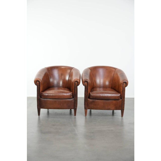 This comfortable and timeless set of two sheepskin club armchairs with a warm and charming vintage look. This stunning set...