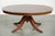 This elegant, oval, English-style coffee table features a red leather top and dates from the 20th century. This...