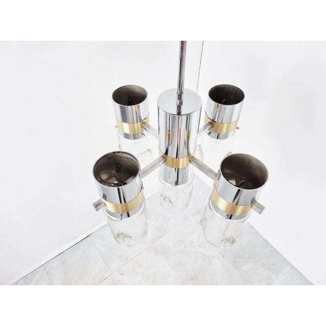 Vintage brass and chrome chandelier with hand made glass shades. The chandelier emits a beautiful light. Very much in the...