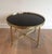This round coffee table is made of brass with a black lacquered glass top. This is a French work by Maison Jansen. Circa 1940