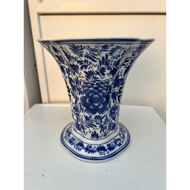 Vintage Chinese blue and white porcelain vase featuring a trumpet shape and floral designs. Features traditional foliage...