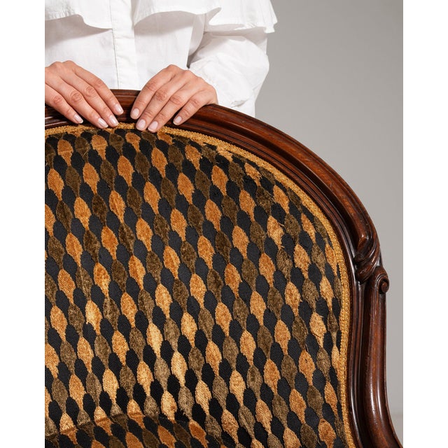 A chair whose dark mahogany, carved scroll, harlequin patterned upholstery gives it real character at first glance. The...