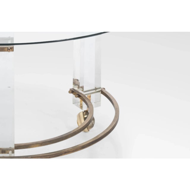 Mid-Century Modern brass Lucite round glass Charles Hollis Jones coffee table. Item features three lucite column-form...