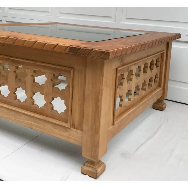 Wow! This is an amazing coffee table made out of teak by Iksun. The top of the table is glass, but everything else is...