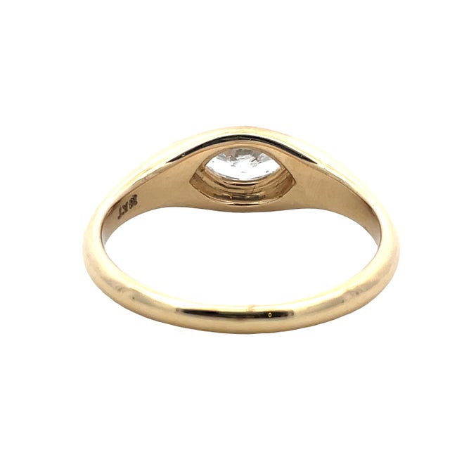 Classic 18K yellow gold signet ring set with a striking 0.64 carat marquise-cut diamond in a smooth bezel-style mount. The...