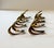 A distinctive set of eight vintage brass napkin rings featuring an elegant sculptural form. Each piece has a sweeping,...