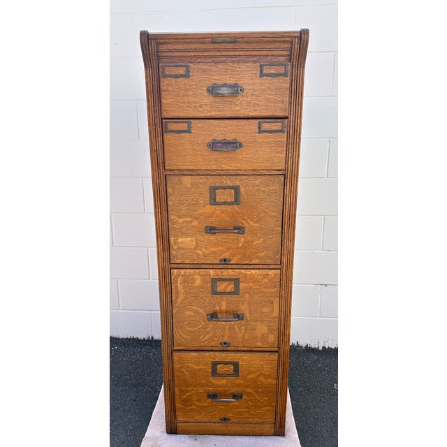 An antique five drawer Yawman & Frbe MFG Co. Oak file cabinet with solid brass pulls, label holders, knobs and original...