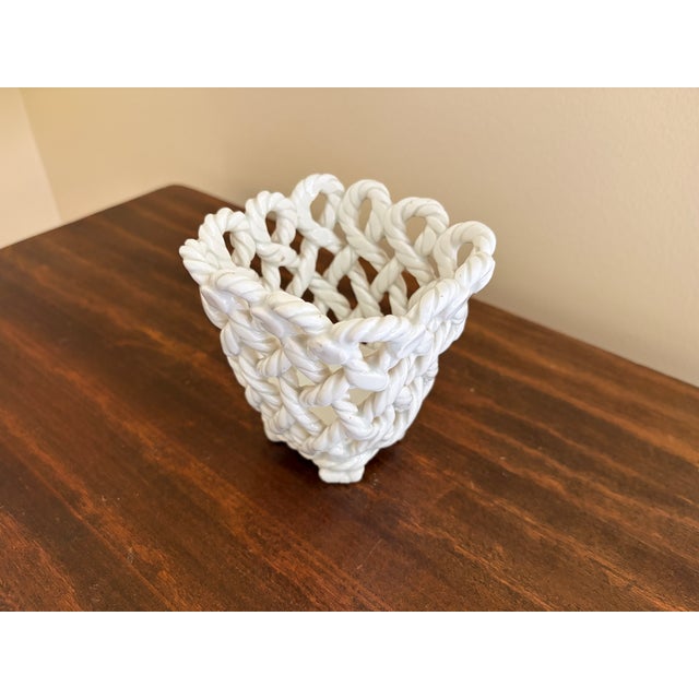 An elegant trompe l'oeil porcelain cachepot crafted in the form of a handwoven rope basket. Executed in glossy white...