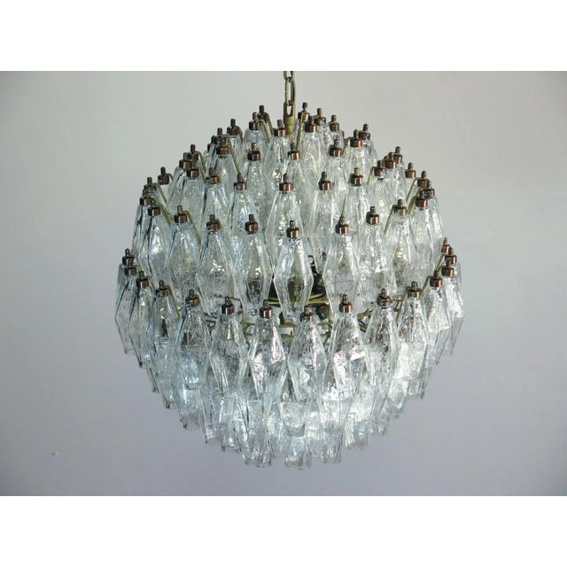 Elegant Italian pendant light made from 140 transparent Murano glasses ''poliedri''. Structure in gold and brass colored...