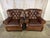A commanding pair of oversized leather tufted club chairs that embody the timeless sophistication of a British gentlemen’s...