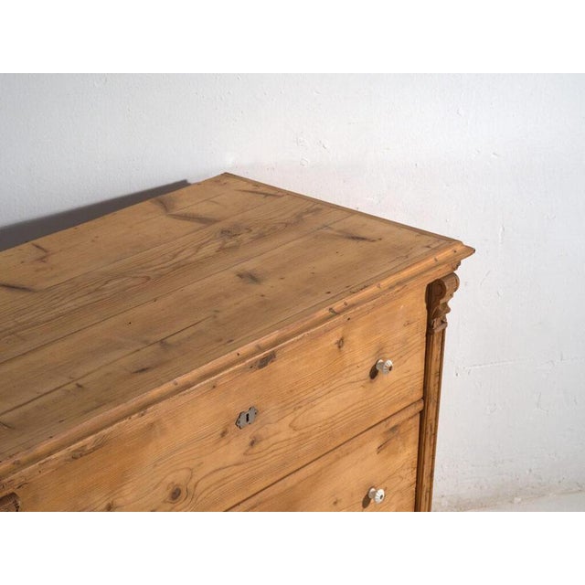 This antique pine wood chest of drawers from Europa Central, dating to c.1900, represents traditional early...