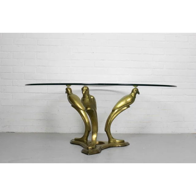Hollywood Regency beautiful brass coffee table with parrot base in the manner of Willy Daro, made in Belgium 1970. Glass...